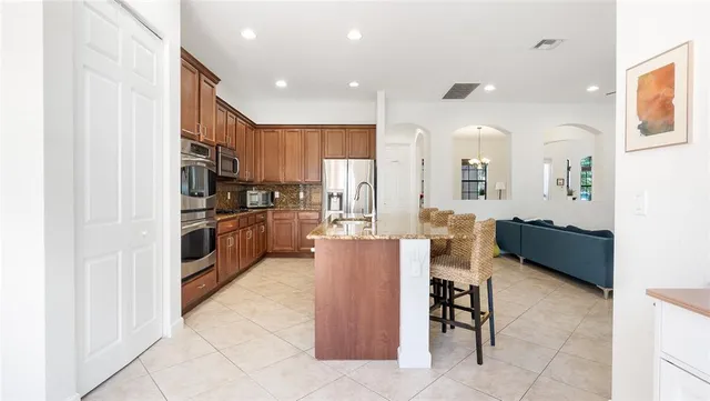 a kitchen with stainless steel appliances granite countertop a sink stove microwave and refrigerator