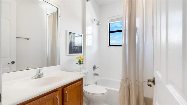 a bathroom with a granite countertop sink toilet mirror and shower