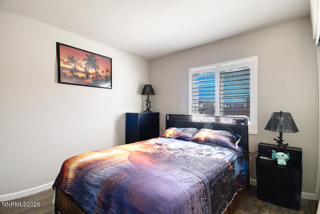 8957 Buffalo Grove Drive Reno, NV 89506 - Photo 28 of 59 a bedroom with a bed and wooden floor