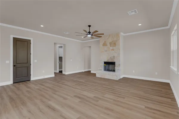 an empty room with wooden floor and a ceiling fan