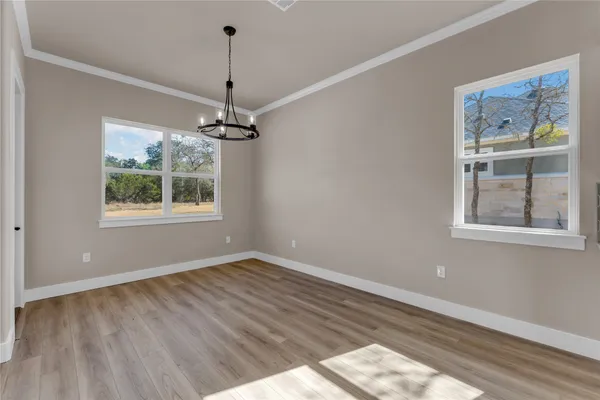 a view of a room with wooden floor a ceiling fan and windows