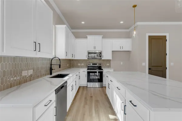 a large kitchen with stainless steel appliances granite countertop a sink stove and refrigerator