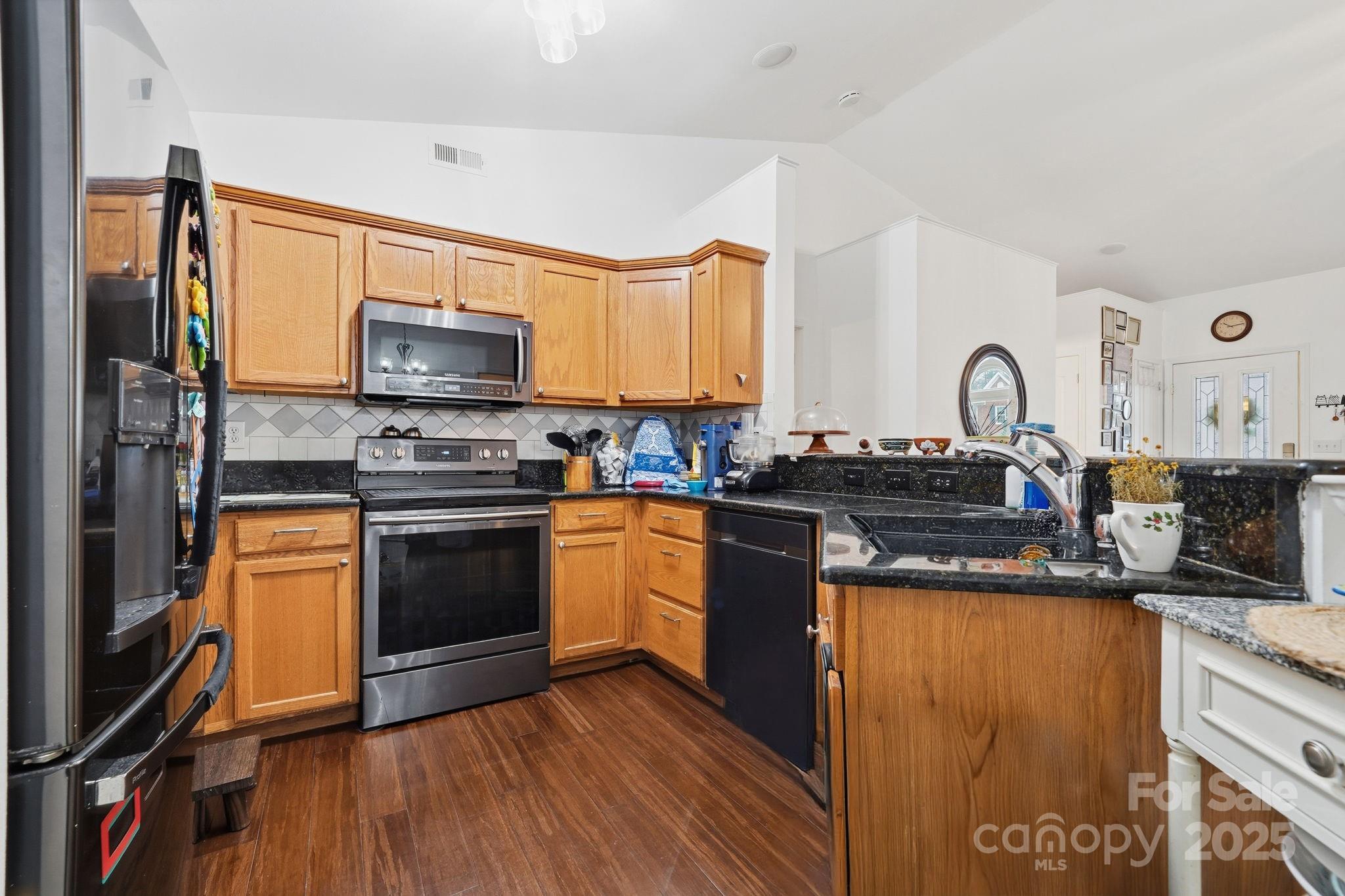 13512 Michael Lynn Road Charlotte, NC 28278 - Photo 7 of 36 a kitchen with stainless steel appliances granite countertop a stove a sink dishwasher a refrigerator and a microwave oven with wooden floor