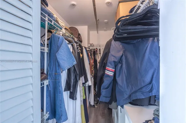 a view of walk in closet with clothes