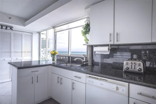 a kitchen with sink a window and cabinets