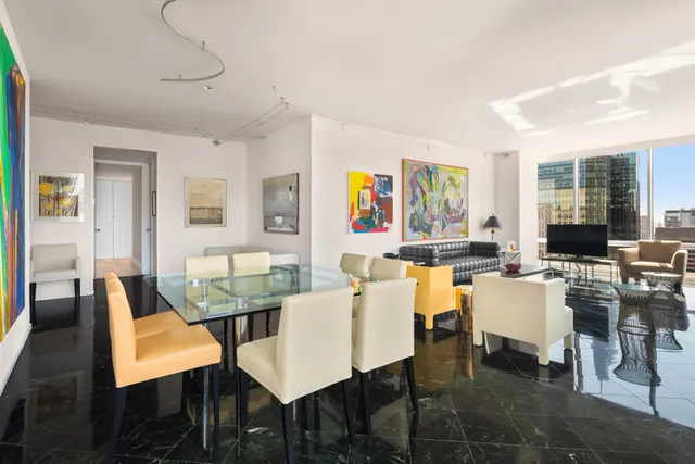 a living room with furniture a flat screen tv and a floor to ceiling window