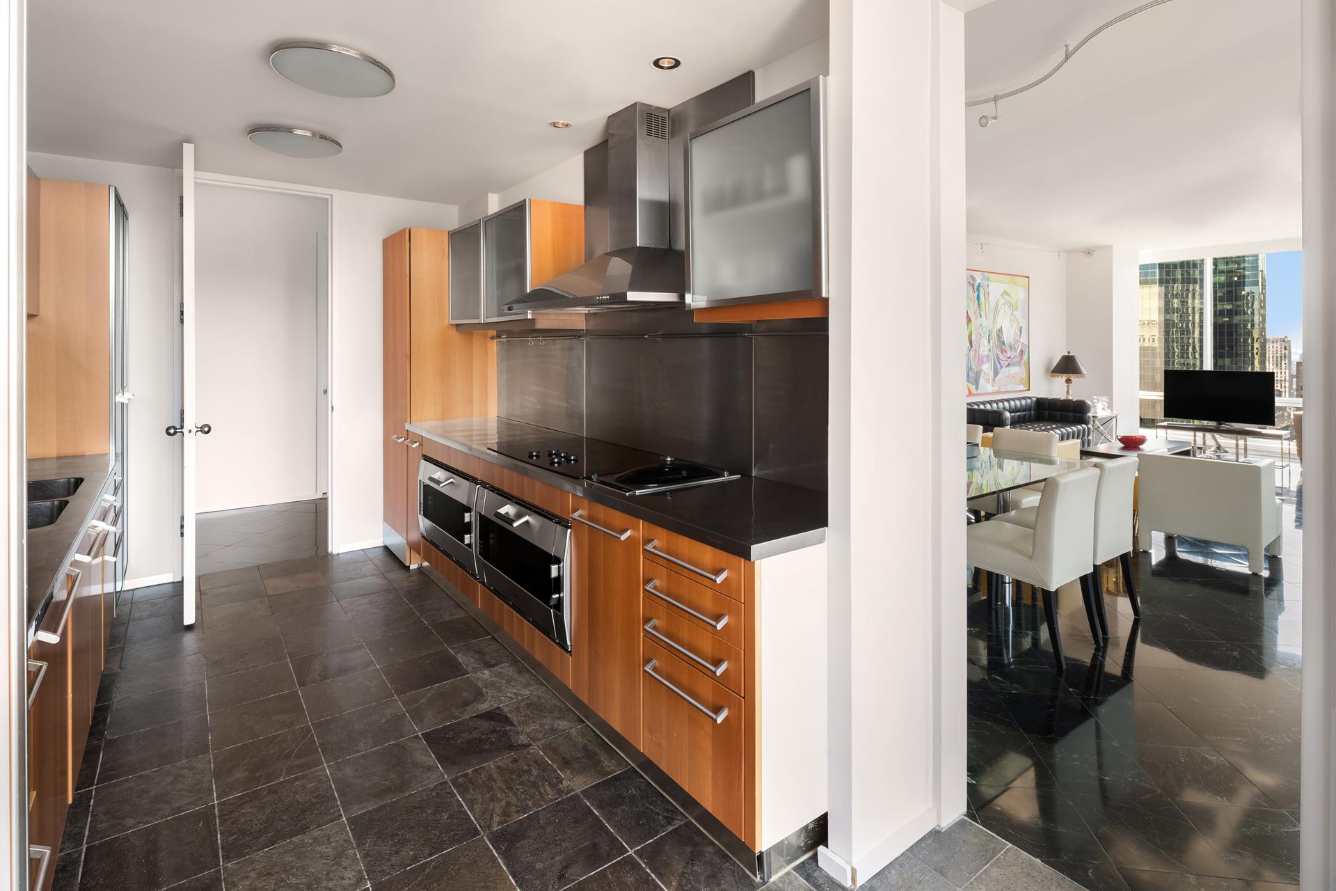 641 5th Avenue, Unit 42H Manhattan, NY 10022 - Photo 7 of 16 a kitchen with stainless steel appliances a stove and cabinets