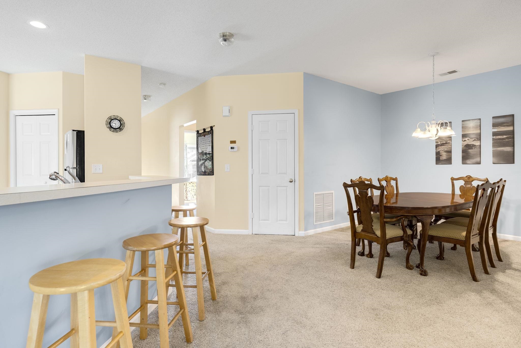 4499 Girvan Drive, Unit H Myrtle Beach, SC 29579 - Photo 16 of 35 Dining space featuring light colored carpet and a chandelier