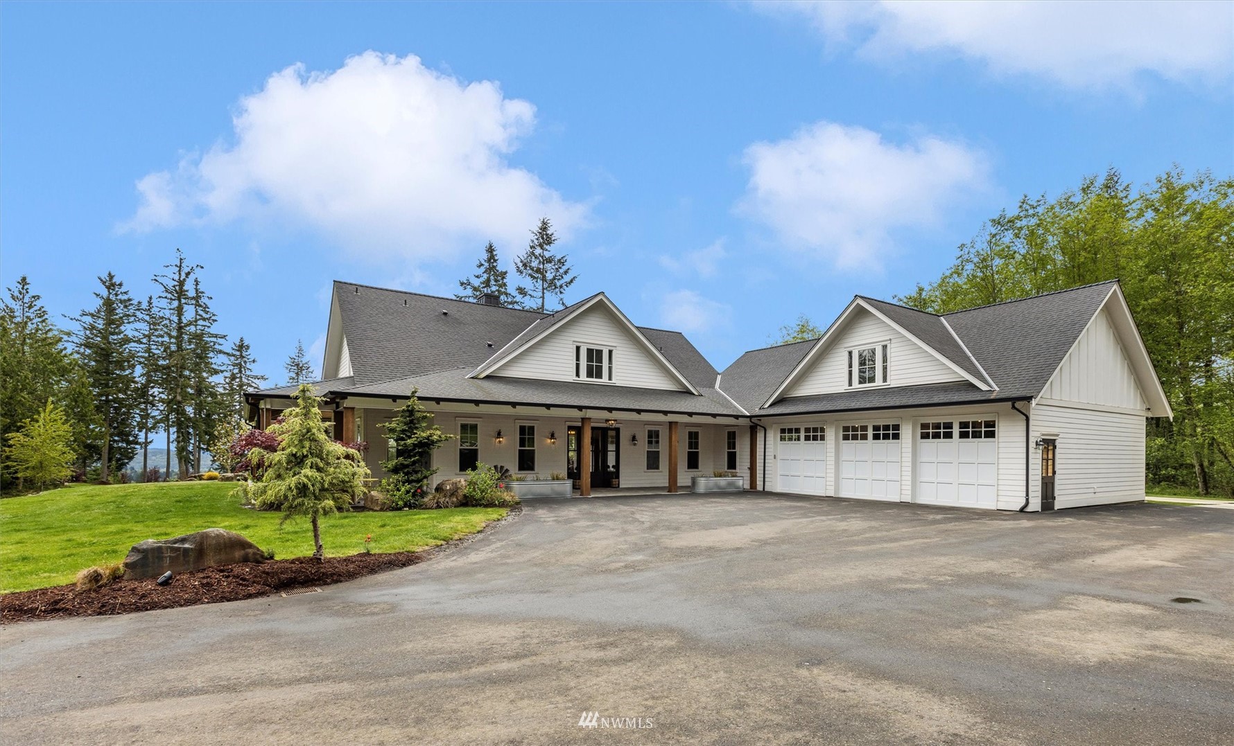 a view of a house with a big yard and large trees