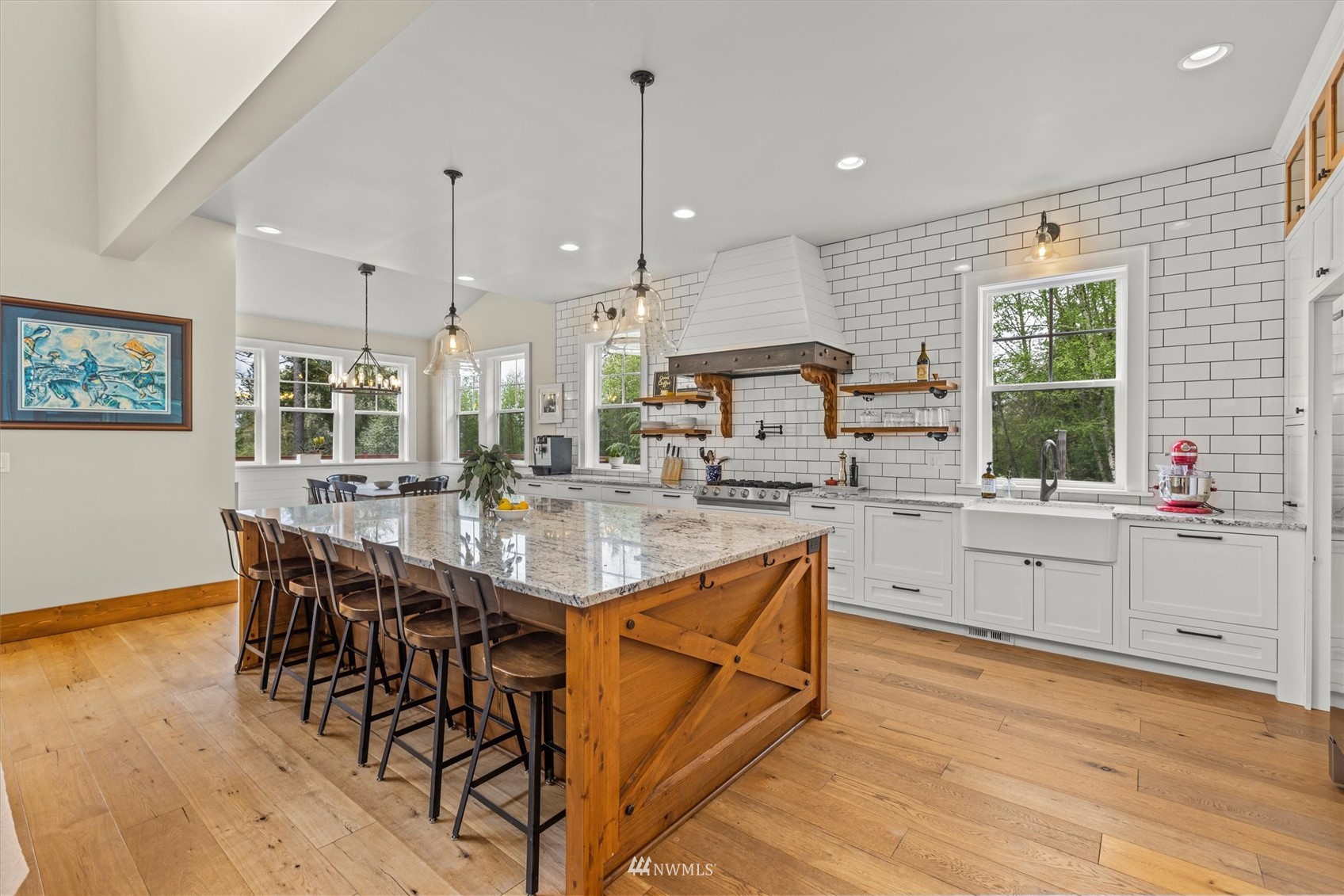 8209 Spada Road Snohomish, WA 98290 - Photo 11 of 39 a kitchen with stainless steel appliances kitchen island granite countertop a stove a sink and white cabinets with wooden floor