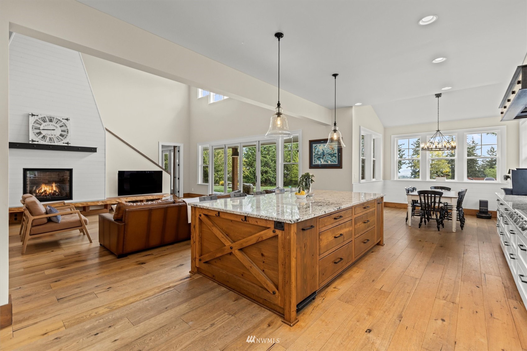 8209 Spada Road Snohomish, WA 98290 - Photo 15 of 39 a large living room with stainless steel appliances granite countertop couches a fireplace with wooden floor