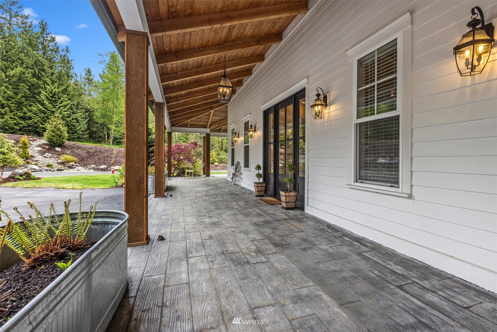 8209 Spada Road Snohomish, WA 98290 - Photo 4 of 39 a view of a porch with wooden floor and roof with a garden view