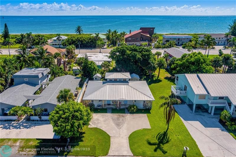 an aerial view of a house with a garden and lake view