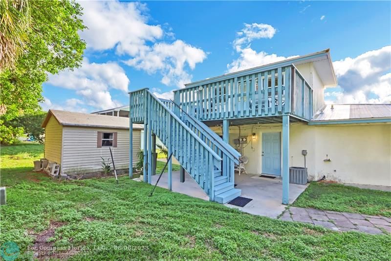1128 Hernando Street Fort Pierce, FL 34949 - Photo 18 of 46 a view of a house with brick walls and a yard with plants