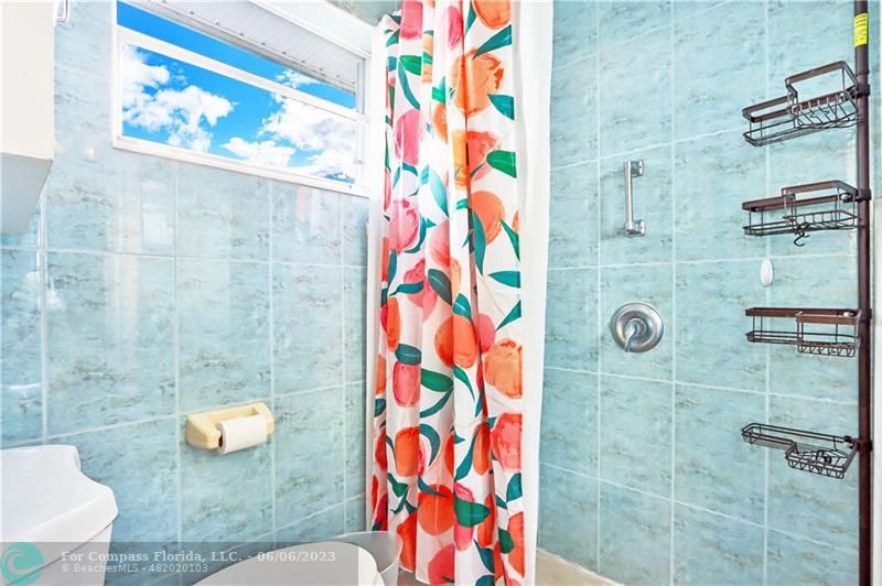 1128 Hernando Street Fort Pierce, FL 34949 - Photo 24 of 46 a bathroom with a toilet and shower curtain