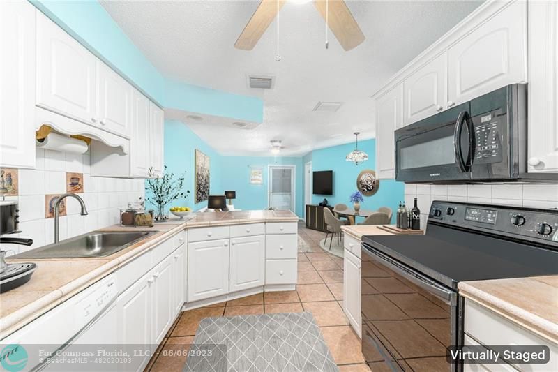 1128 Hernando Street Fort Pierce, FL 34949 - Photo 29 of 46 a large white kitchen with stainless steel appliances granite countertop a sink and cabinets