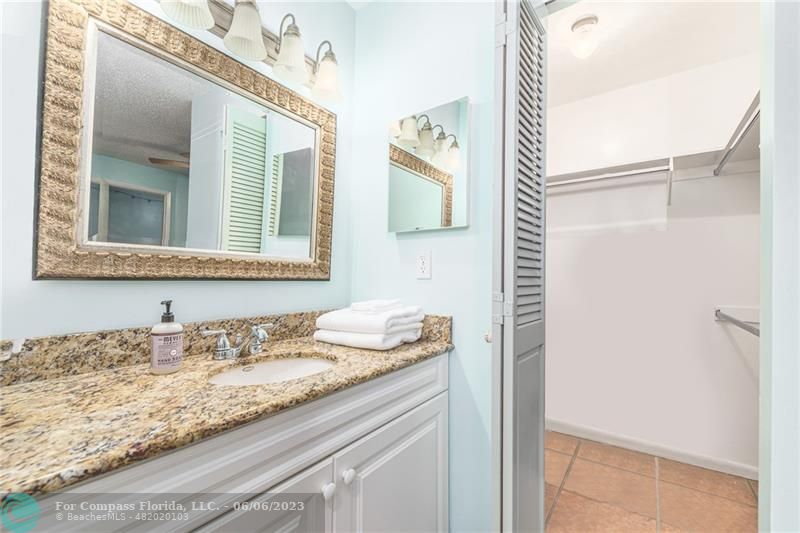 1128 Hernando Street Fort Pierce, FL 34949 - Photo 33 of 46 a bathroom with a granite countertop sink and a mirror