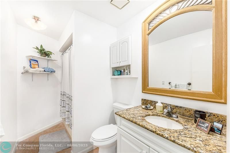 1128 Hernando Street Fort Pierce, FL 34949 - Photo 35 of 46 a bathroom with a granite countertop sink a toilet and a mirror
