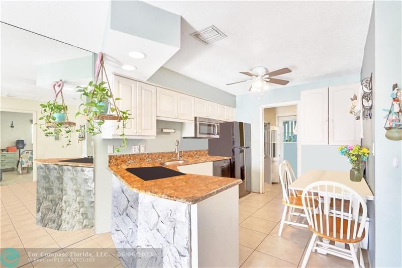 1128 Hernando Street Fort Pierce, FL 34949 - Photo 5 of 46 a kitchen with stainless steel appliances kitchen island granite countertop cabinets and wooden floor