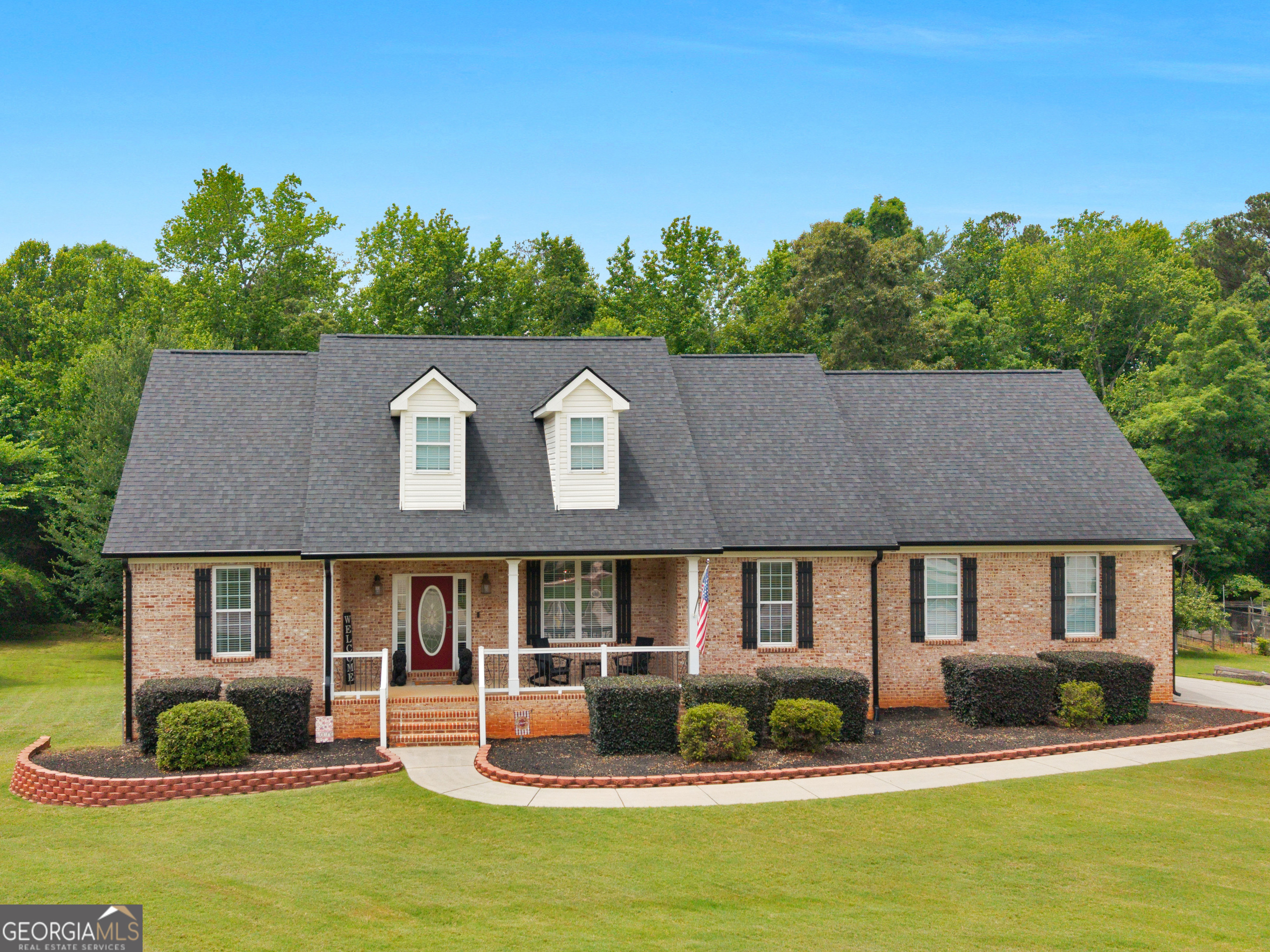 a front view of a house with swimming pool and outdoor seating