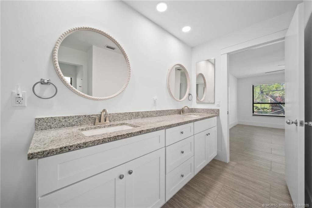 2284 Southwest Spoonbill Drive Palm City, FL 34990 - Photo 18 of 30 a bathroom with a granite countertop double vanity sink and a mirror