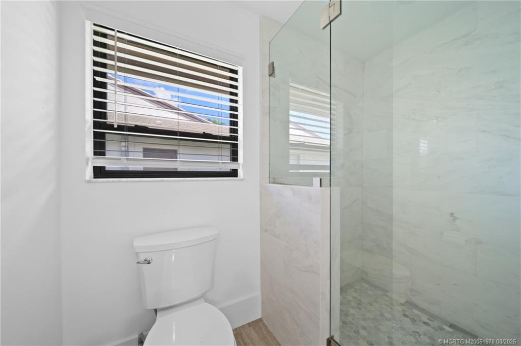 2284 Southwest Spoonbill Drive Palm City, FL 34990 - Photo 19 of 30 a bathroom with a toilet a sink and a shower