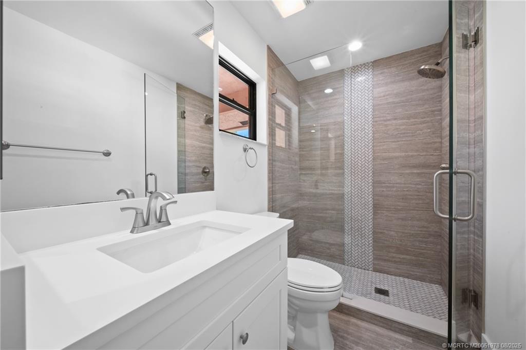 2284 Southwest Spoonbill Drive Palm City, FL 34990 - Photo 20 of 30 a bathroom with a sink a toilet and shower