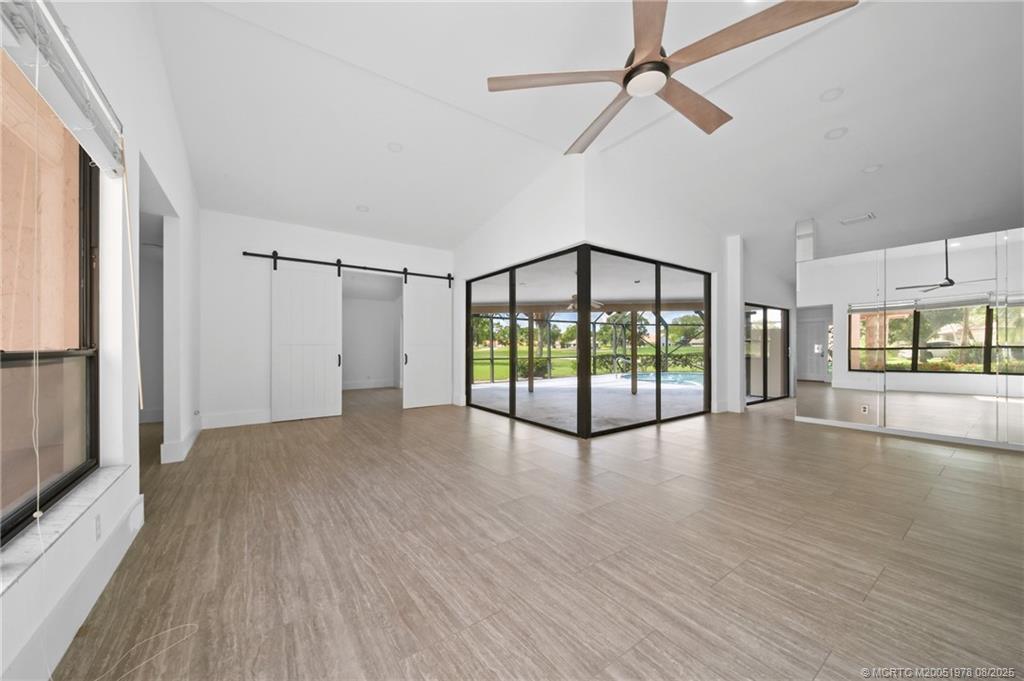 2284 Southwest Spoonbill Drive Palm City, FL 34990 - Photo 9 of 30 a view of an empty room with wooden floor and a window