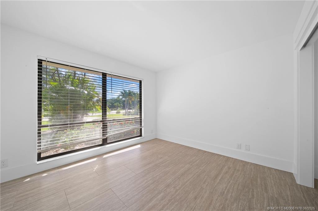 2284 Southwest Spoonbill Drive Palm City, FL 34990 - Photo 10 of 30 an empty room with wooden floor and windows