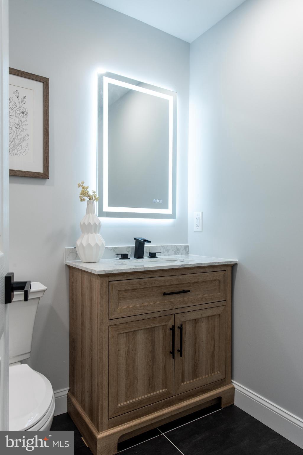 617 Greenbrier Drive Silver Spring, MD 20910 - Photo 51 of 70 a bathroom with a granite countertop toilet sink and mirror