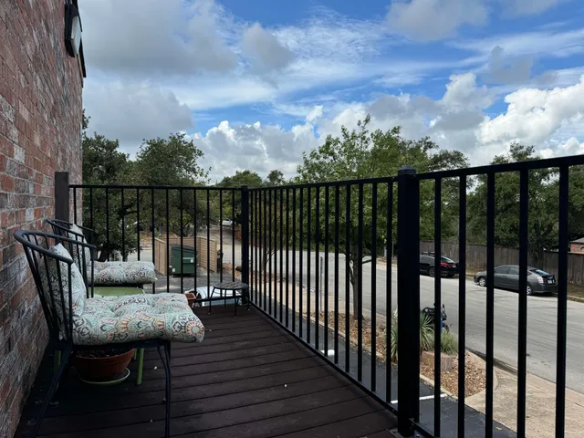 a view of a balcony with wooden floor and outdoor seating