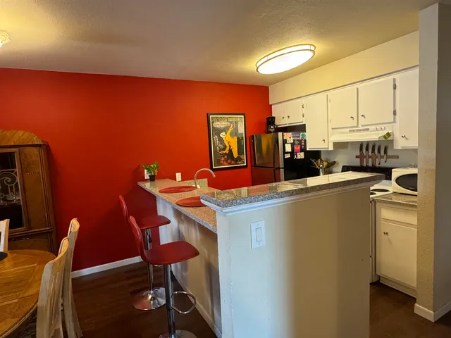 a room with furniture a air conditioner vent and a window