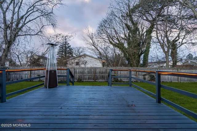 a view of park with large trees and wooden fence