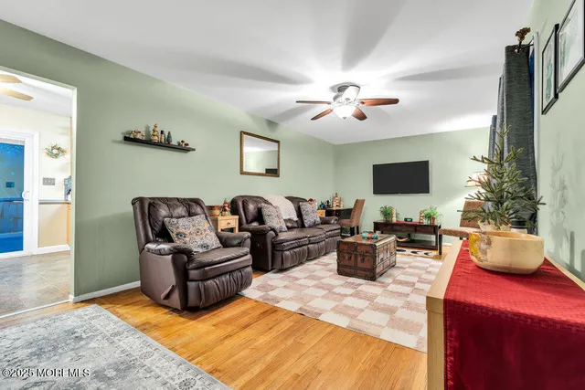 a living room with furniture a chandelier and a flat screen tv