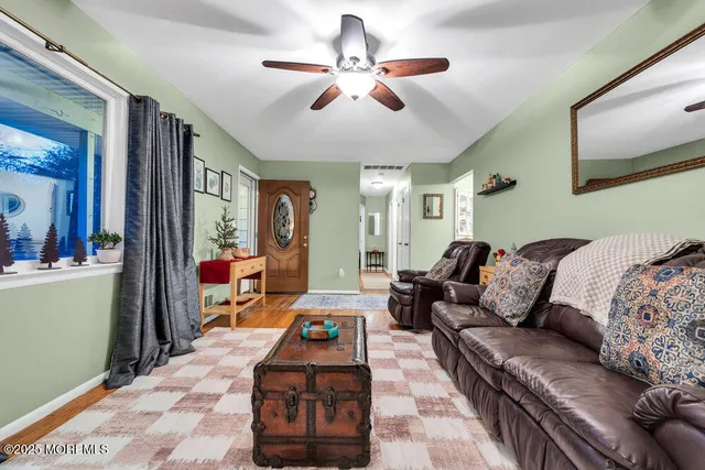 a living room with furniture ceiling fan and a rug