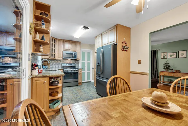 a kitchen with stainless steel appliances kitchen island granite countertop a refrigerator and a stove top oven