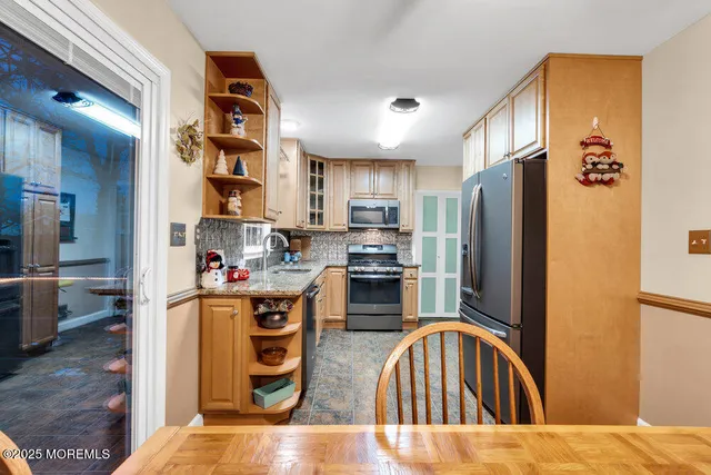a kitchen with stainless steel appliances granite countertop a refrigerator a stove and a sink