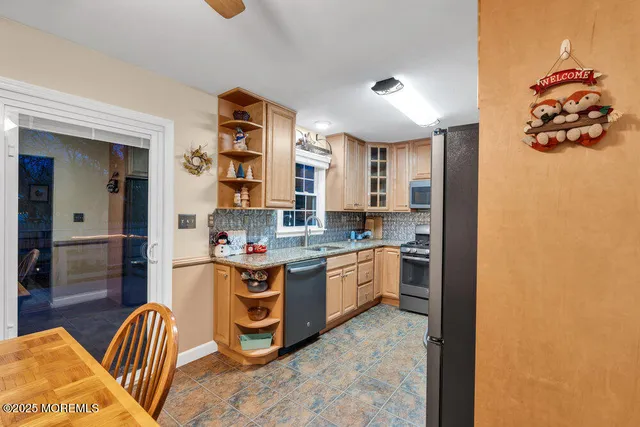 a kitchen with stainless steel appliances granite countertop a sink and a refrigerator