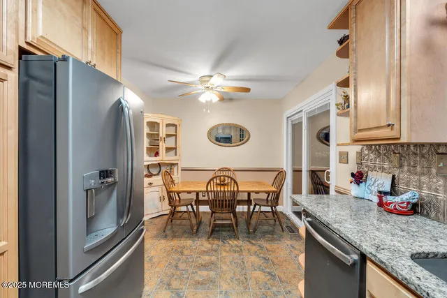 a dining room with stainless steel appliances granite countertop furniture and a kitchen view