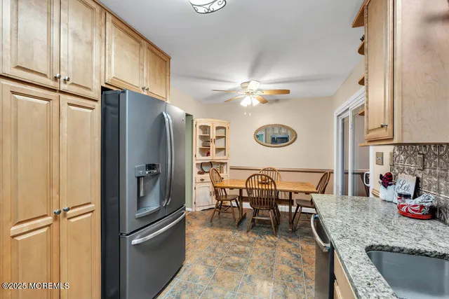 a kitchen with stainless steel appliances granite countertop a refrigerator a oven a sink and a dining table