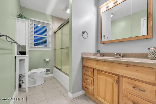 a bathroom with a granite countertop toilet sink and mirror
