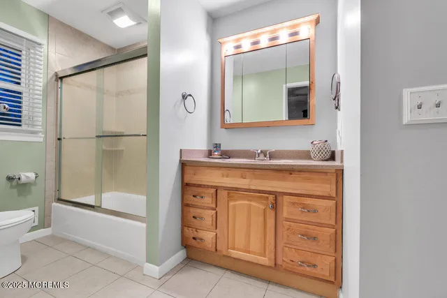 a bathroom with a granite countertop sink mirror and a toilet