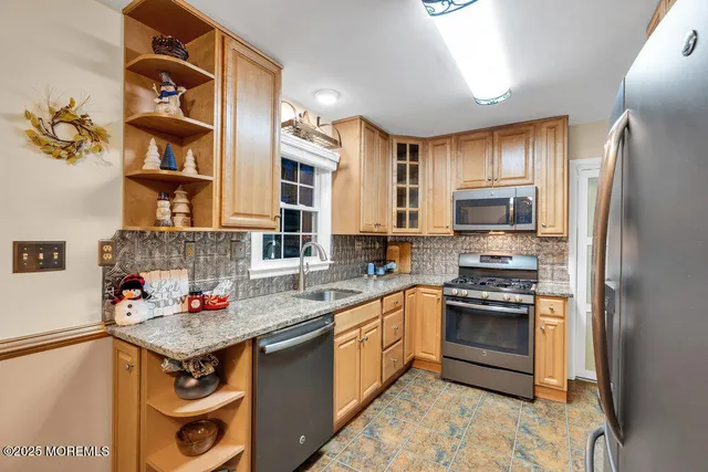 a kitchen with stainless steel appliances granite countertop a stove refrigerator and cabinets
