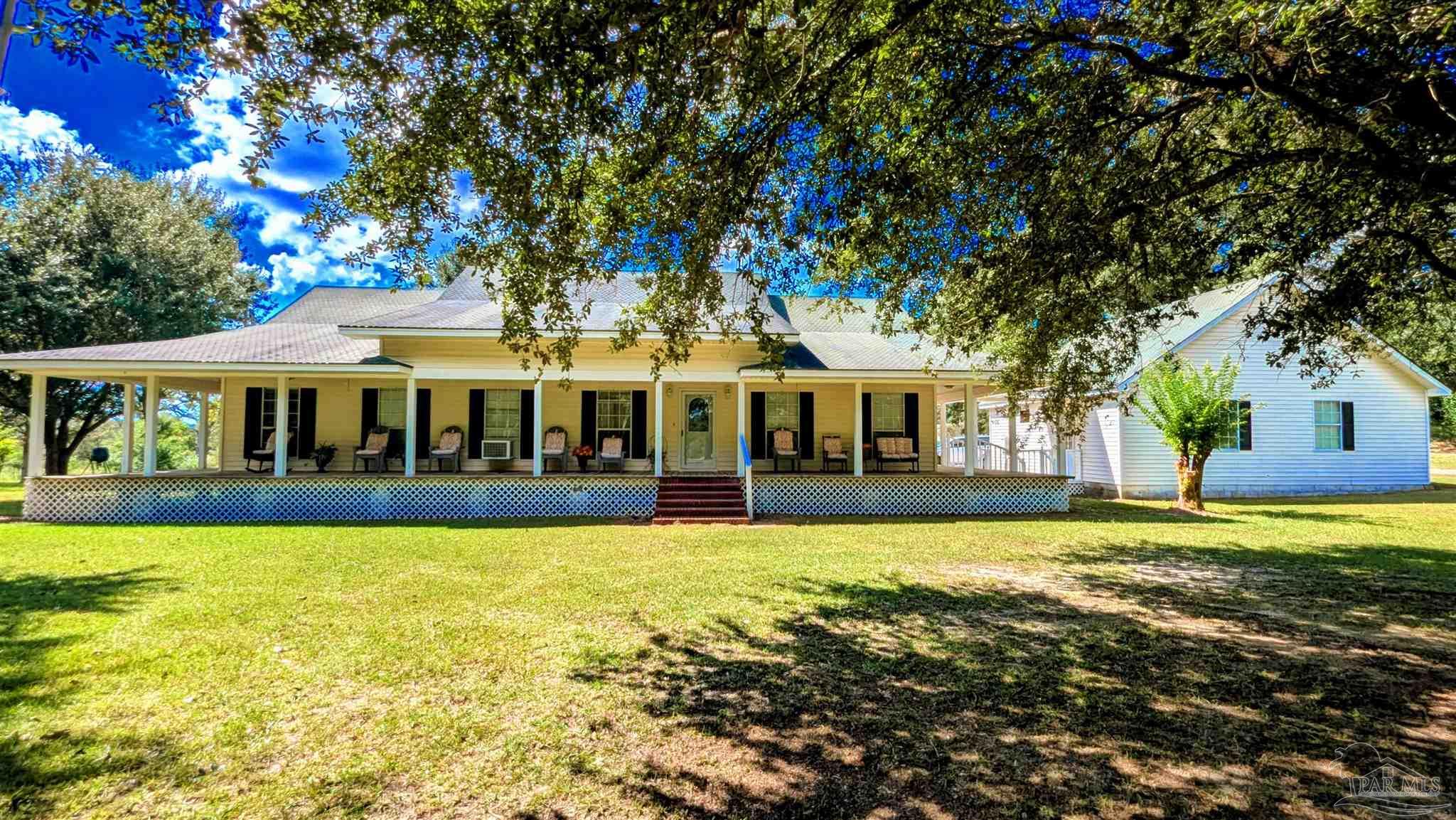 a view of a house with swimming pool and a yard