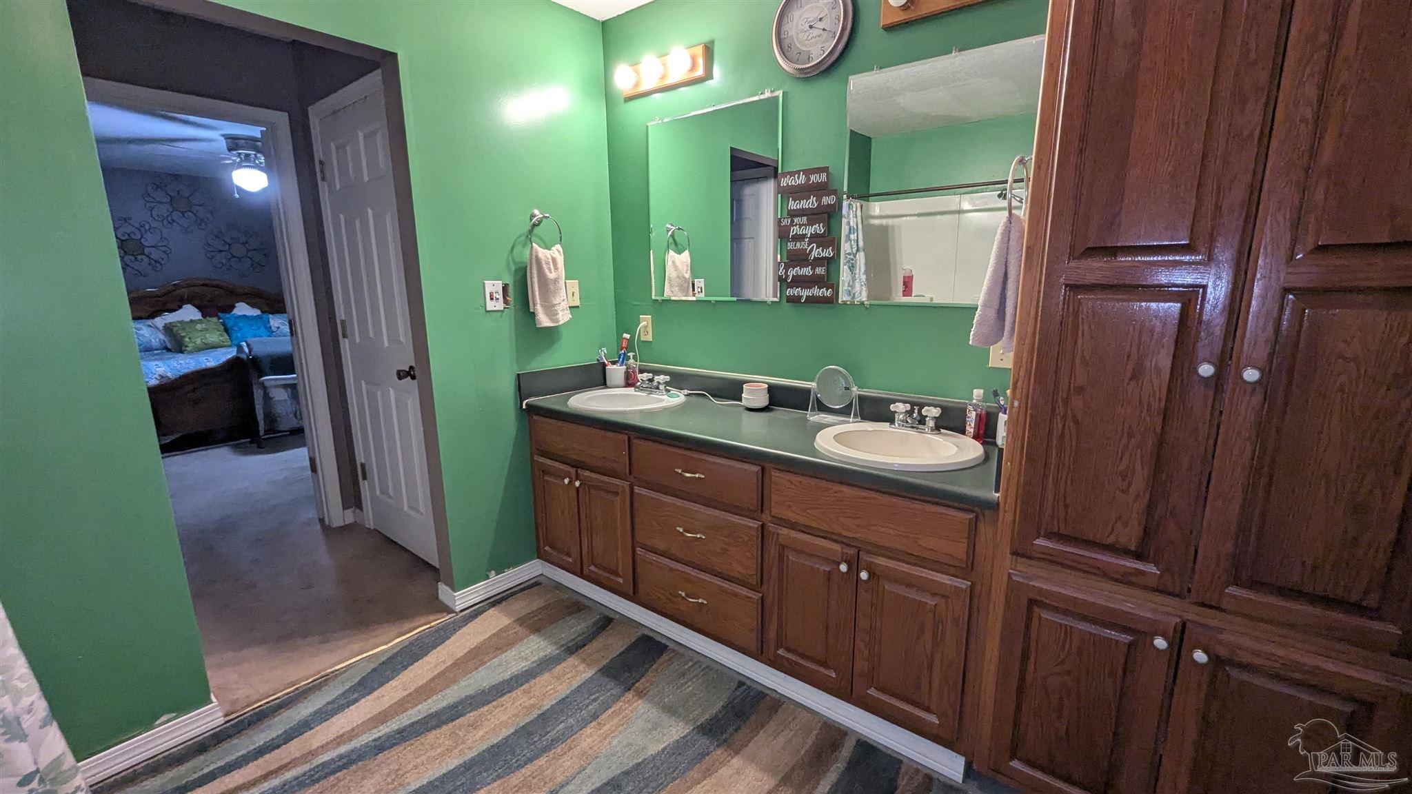 3171 Sam Sullivan Road Millry, AL 36558 - Photo 39 of 72 a spacious bathroom with a double vanity sink and a mirror
