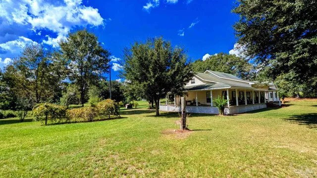 a front view of a house with swimming pool and trees
