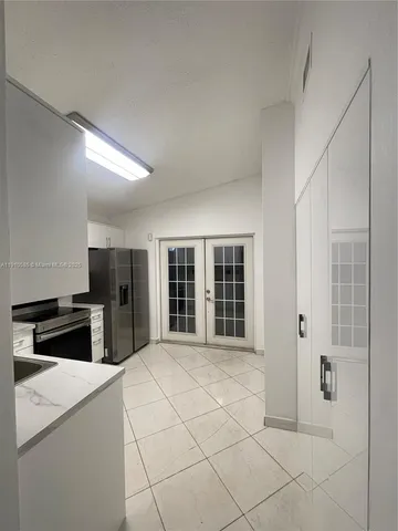 a kitchen with stainless steel appliances kitchen island granite countertop a refrigerator and a sink