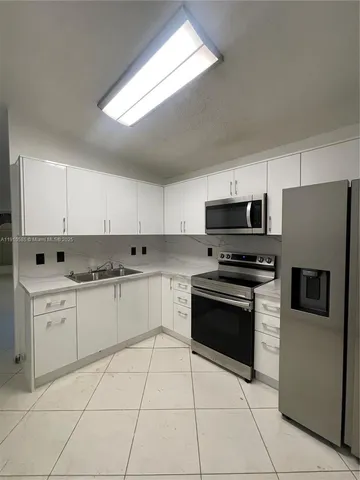 a kitchen with stainless steel appliances granite countertop a refrigerator sink and stove