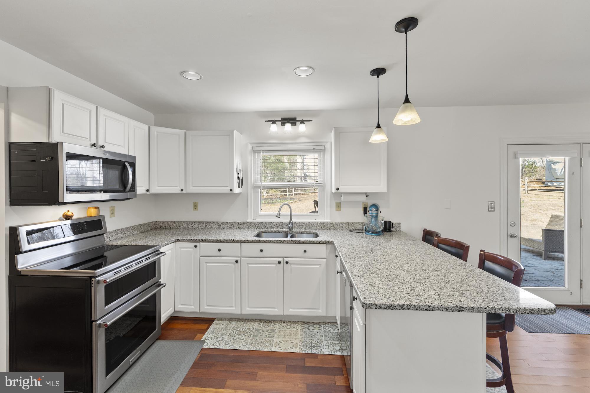 2300 Pin Oak Drive Finksburg, MD 21048 - Photo 9 of 52 a kitchen with granite countertop a sink stainless steel appliances and white cabinets