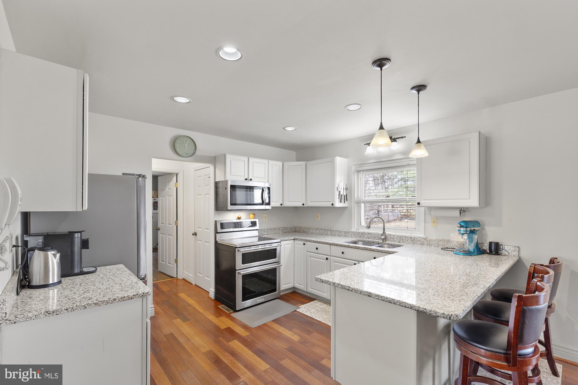2300 Pin Oak Drive Finksburg, MD 21048 - Photo 10 of 52 a kitchen with stainless steel appliances granite countertop a sink a stove a refrigerator and island